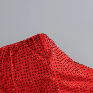 Close-up of red evening dress featuring intricate hot-fix rhinestones and fabric texture