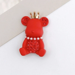 Detail shot of a red rubber-finish crown bear charm with pearls and red rhinestones