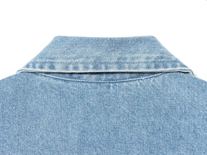 Detalle macro del cuello polo y la textura del tejido denim en chaqueta azul