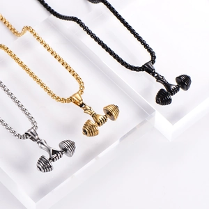 Macro detail of three stainless steel dumbbell pendants in silver, gold, and black