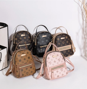 Detailed view of mini floral monogram backpacks in brown, black, and pink with gold hardware