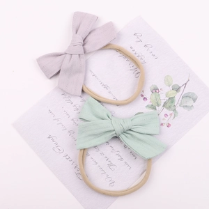 Detail showing soft elastic baby headbands with lavender and light green fabric bows