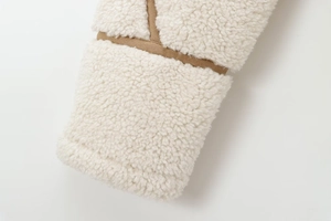 Détail de la veste en polaire crème avec bordure marron et texture douce et pelucheuse