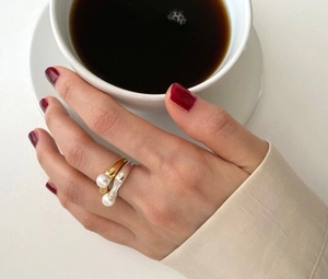Detailed view of S925 silver liquid metal rings with pearls on model finger