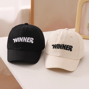 Detail of winner 3D embroidery on cotton baseball caps in black and cream colors