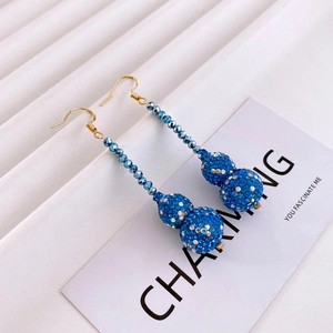 Detail of blue rhinestone double sphere tassel earrings with elegant golden metal hooks