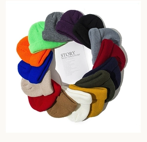 Flat lay of knit beanies in multiple vibrant colors arranged in a circular artistic layout