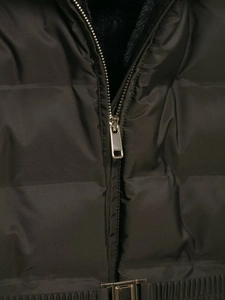 Detail of premium gold metal zipper and quilted waterproof fabric on black padded jacket