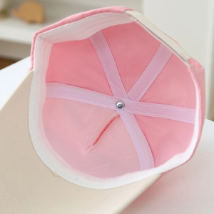 Internal detail of kids baseball cap featuring pink mesh lining and reinforced stitching
