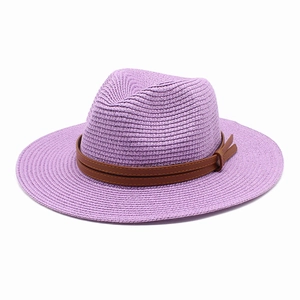 Détail du chapeau de soleil tressé violet avec ruban en cuir brun et texture de jazz