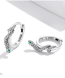 Macro shot of S925 silver snake earrings with green zircon eyes and scale texture