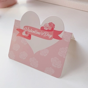Close-up of pink Valentine's Day card with rose patterns and heart-shaped cutout detail