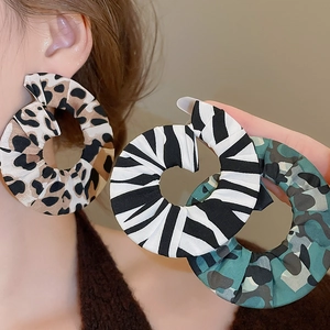 Detailed view of oversized hoop earrings in leopard, zebra, and camo fabric prints