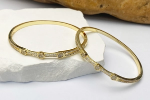 Vista macro dettagliata di due lussuosi bracciali placcati in oro con pietre di zircone