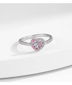 Detailed macro view of heart-shaped silver ring with pink enamel and sparkling crystals