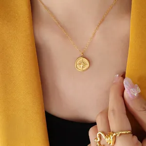 Compass coin pendant necklace in 18K gold plated titanium steel worn with yellow blazer
