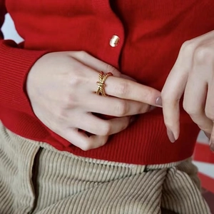 French vintage twisted knot gold ring shown on model against a red knit background