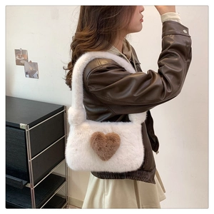 Model wearing white plush shoulder bag with brown plush heart detail for autumn winter