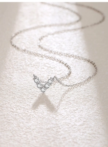 Detailed macro shot of V-shaped silver pendant with sparkling zircon gemstones