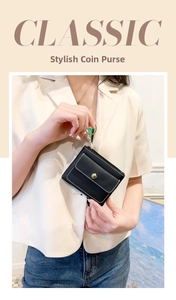 Detailed view of black lychee leather coin purse with white stitching and gold hardware