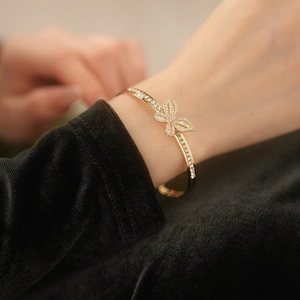 Detailed view of a gold-plated butterfly open bracelet with shimmering zircon accents