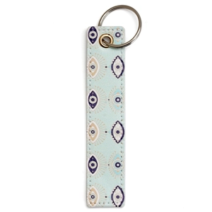 Detail of mint green faux leather keychain with evil eye patterns and silver ring