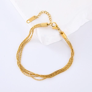 Layered gold stainless steel chain necklace with lobster clasp on marble background