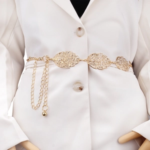 Elegant gold hollow leaf metal waist chain belt with tassel drapes on a white blazer