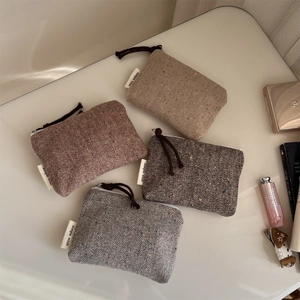 Set of four herringbone tweed mini pouches with colorful speckles and knot zippers