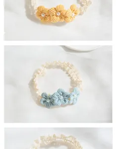 Detail of lace baby headband with three corduroy flowers and faux pearl centers