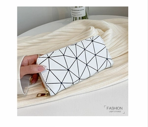 Detail of white women's long wallet featuring geometric triangle pattern and gold zipper