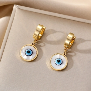 Detailed macro of gold evil eye hoop earrings with white shell inlay in a jewelry box