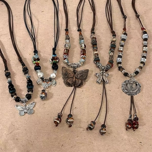 Ethnic style ceramic butterfly pendant necklaces with woven cords on beige background
