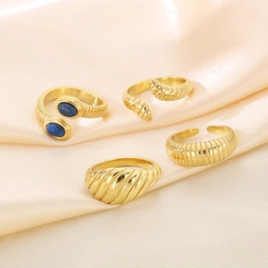 Detailed set of 18K gold-plated snake and textured rings with blue lapis stones on silk
