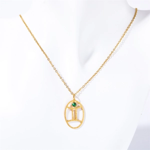 Macro detail of gold stainless steel necklace with green turquoise Gemini constellation