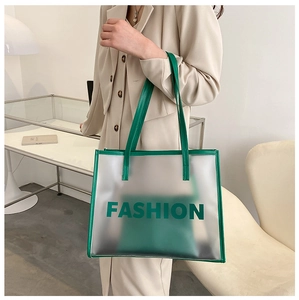 Detail view of transparent green PVC tote bag with leather pouch and Fashion text print