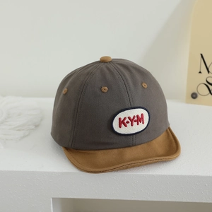 Detailed view of kids canvas baseball cap with KYM embroidered patch and contrast brim