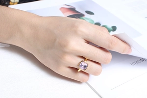 Macro detail of a square purple zircon stone set on a golden stainless steel ring band