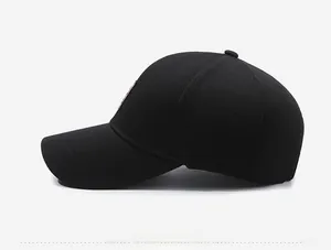 Side view detail of black baseball cap with textured mesh fabric and leather patch