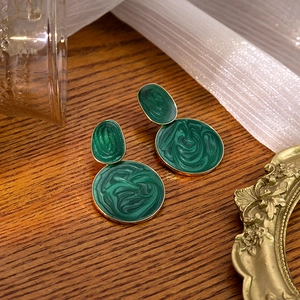 Detailed view of green marble texture enamel earrings on a rustic wood surface