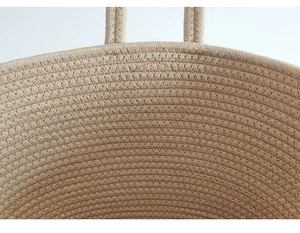 Close-up of the detailed handmade beige cotton rope weaving texture on a beach tote bag