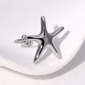 Polished silver stainless steel starfish ring with minimalist design on textured background