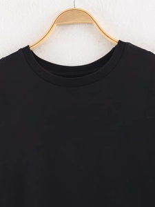 Close-up of crew neckline and lace stitching details on a black cotton t-shirt