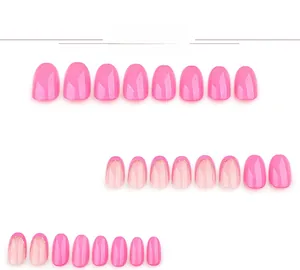 Detail view of pink press-on nails with golden glitter French tips and glossy finish