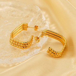 Minimalist gold-plated irregular triple-layer hoop earrings for women on silk background