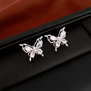 Detail view of silver butterfly stud earrings with sparkling cubic zirconia and small pearls