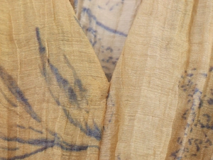 Macro detail of yellow chiffon top showing plisse texture and abstract floral print
