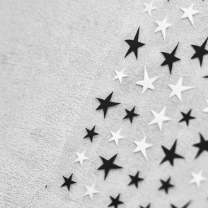 Macro shot of 5-point star embossed nail art stickers in classic black and white patterns