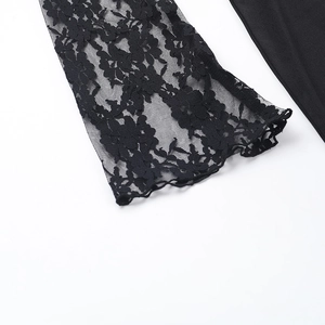 Dettaglio della manica in pizzo floreale nero su un abito da sera attillato elegante
