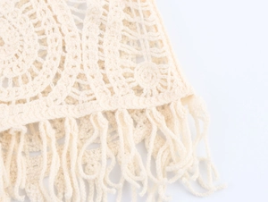 Dettaglio del cardigan all'uncinetto con motivi traforati e lunghe frange decorative